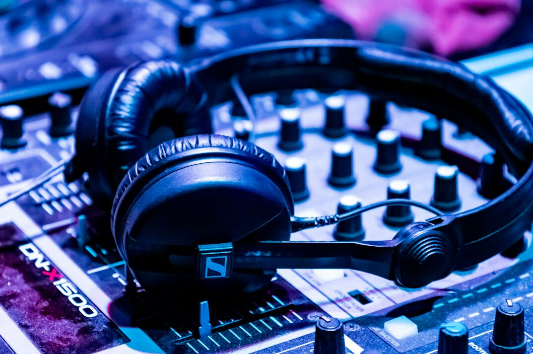 Audio mixing console with faders and headphones